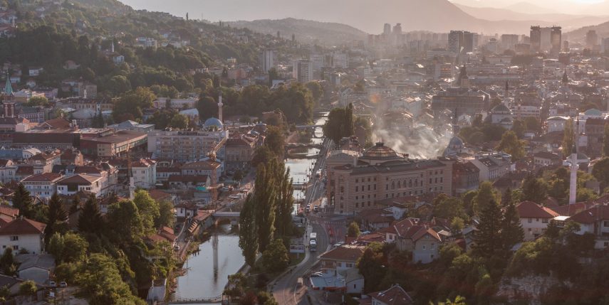 Panoramic aerial cityscape of the historical downtown of Sarajevo timelapse, Bosnia and Herzegovina, with famous buildings and the bridges across Miljacka river before sunset from viewpoint